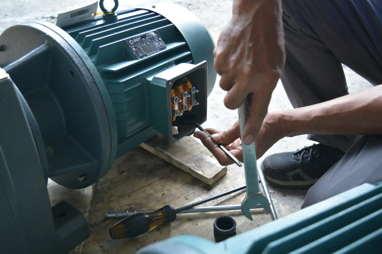 Elektrik motorunun ayak bağlantısında anahtarla çalışan teknisyen