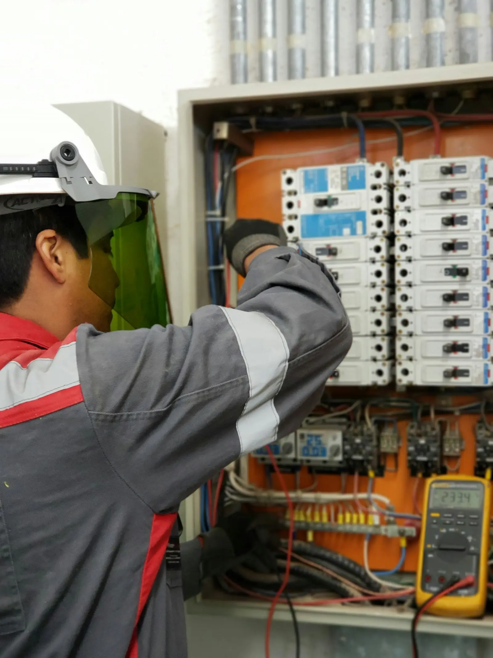 Elektrik panosunda ölçüm yapan teknisyen